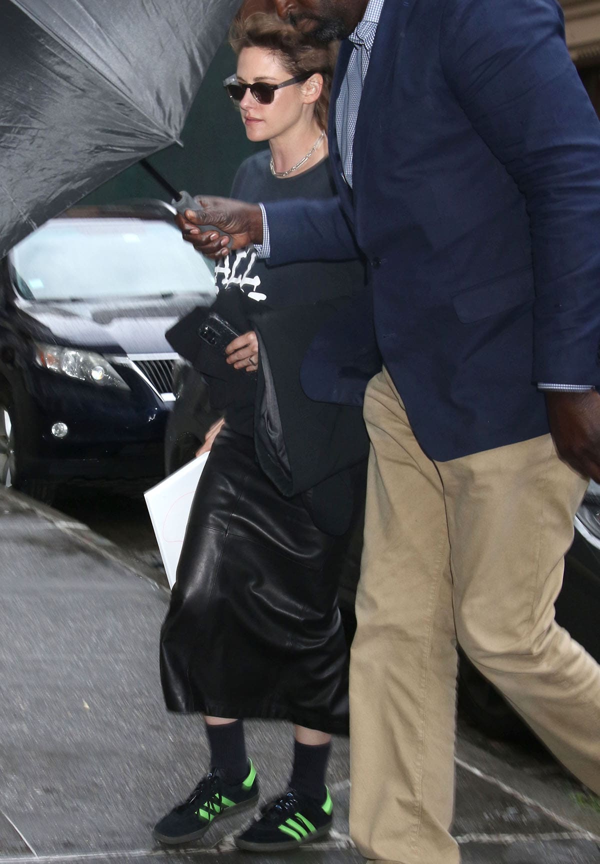 Kristen Stewart gives her black leather Alex Perry midi dress a sporty jolt with black-and-Lucid Lime Adidas Samba Deco SPZL sneakers