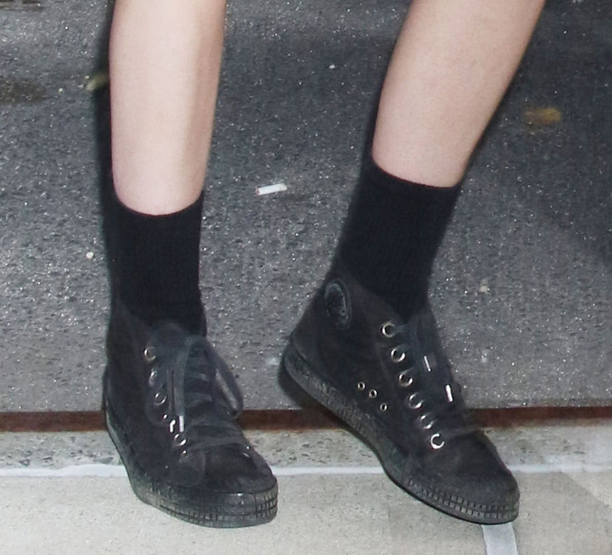 Kristen Stewart leans into her signature grunge aesthetic in black Ruby Brown “3306 Dames” mid-cut canvas sneakers, featuring rubber toe caps, silver-tone eyelets, and Chuck Taylor-inspired styling
