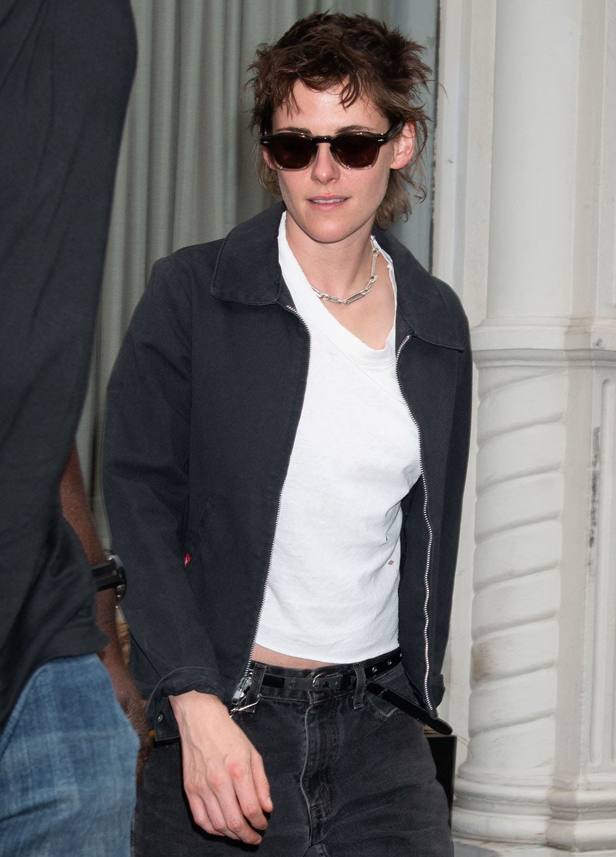 Kristen Stewart pairs her Dublin sneakers with mid-rise faded black jeans, a white tee, and a black Dickies jacket