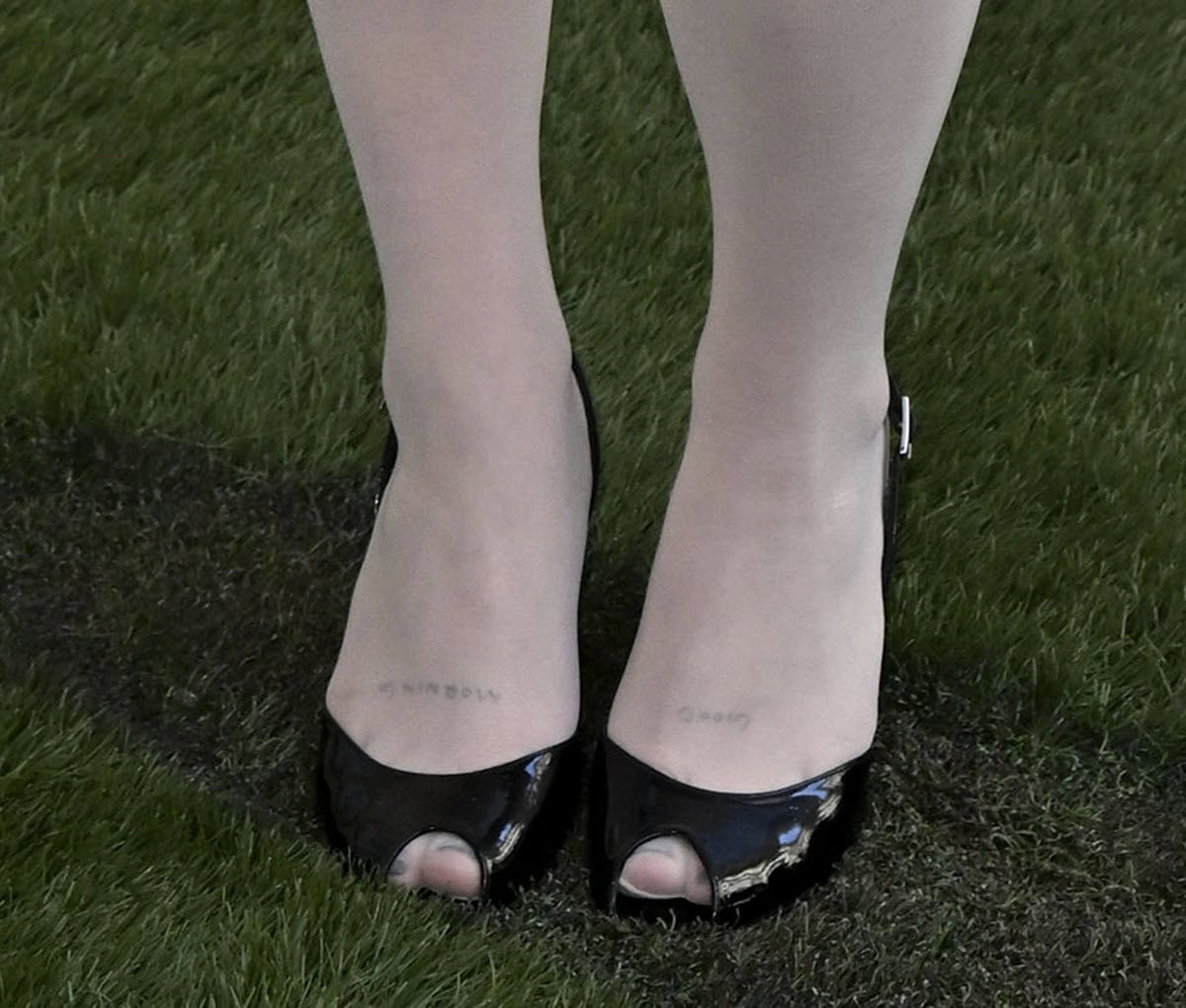 Maisy Stella gives classic black pumps a retro twist, layering sheer knee-high socks over glossy Stuart Weitzman patent-leather peep-toe slingbacks