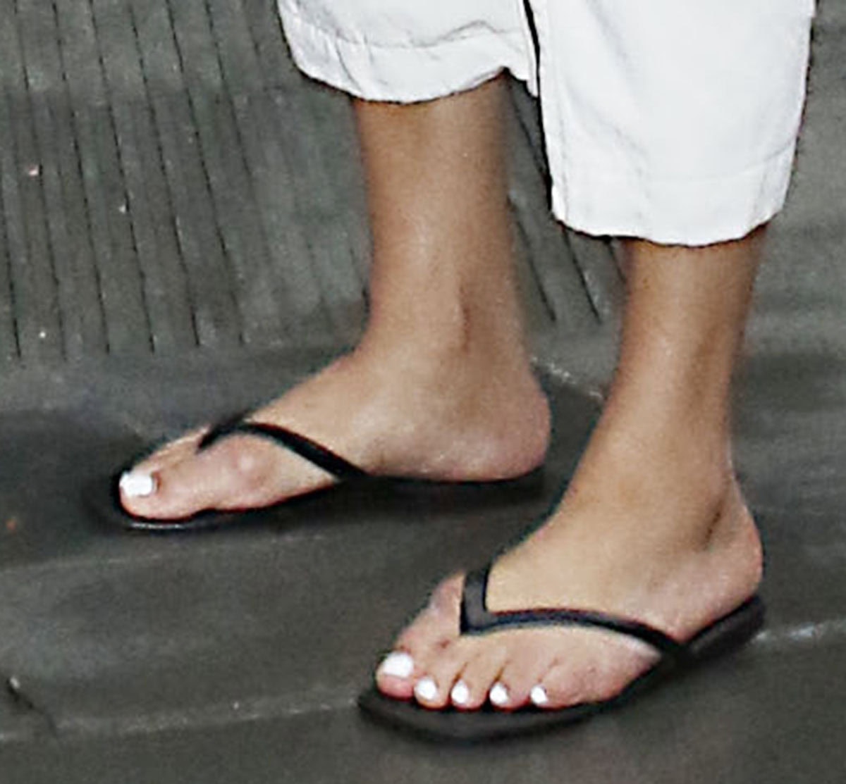 Michelle Buteau keeps things comfy in black flip-flops before switching to snakeskin pumps inside the studio