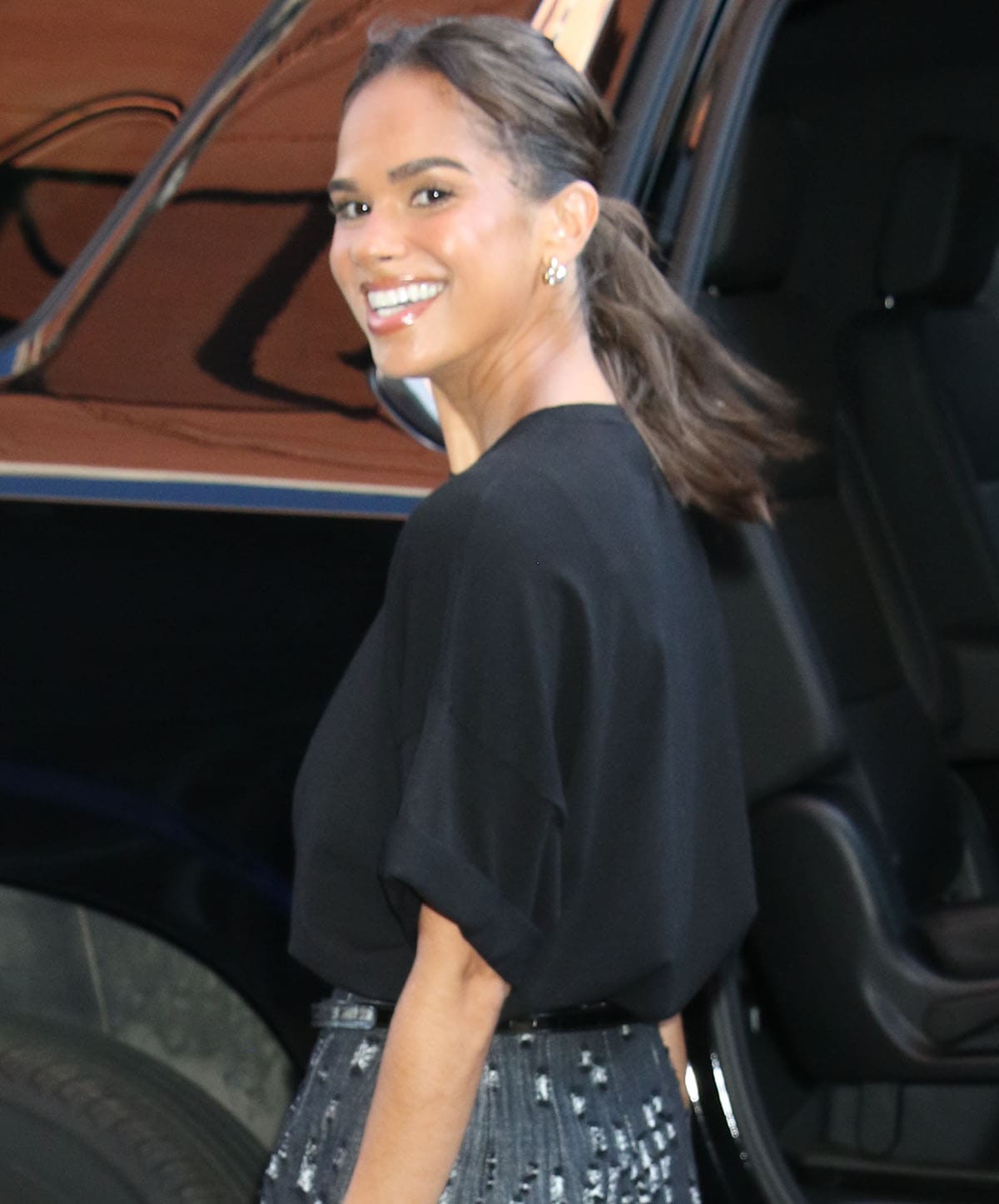 Misty Copeland styles her look with a pair of earrings, a ring, and a casual ponytail