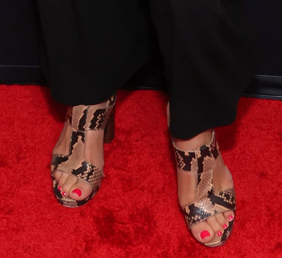 Nona Melkonian walks on the wild side in her Michael Kors “Becker” sandals in snake-print leather featuring wide straps and thick block heels