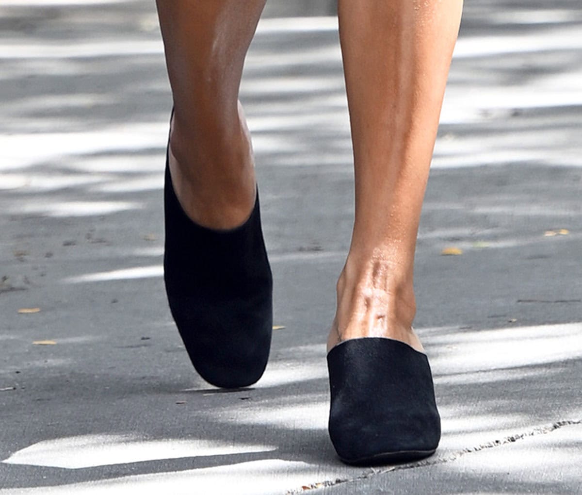 A close-up reveals the Adela mules’ softly squared toes, high-cut suede vamps, and minimalist slip-on silhouette
