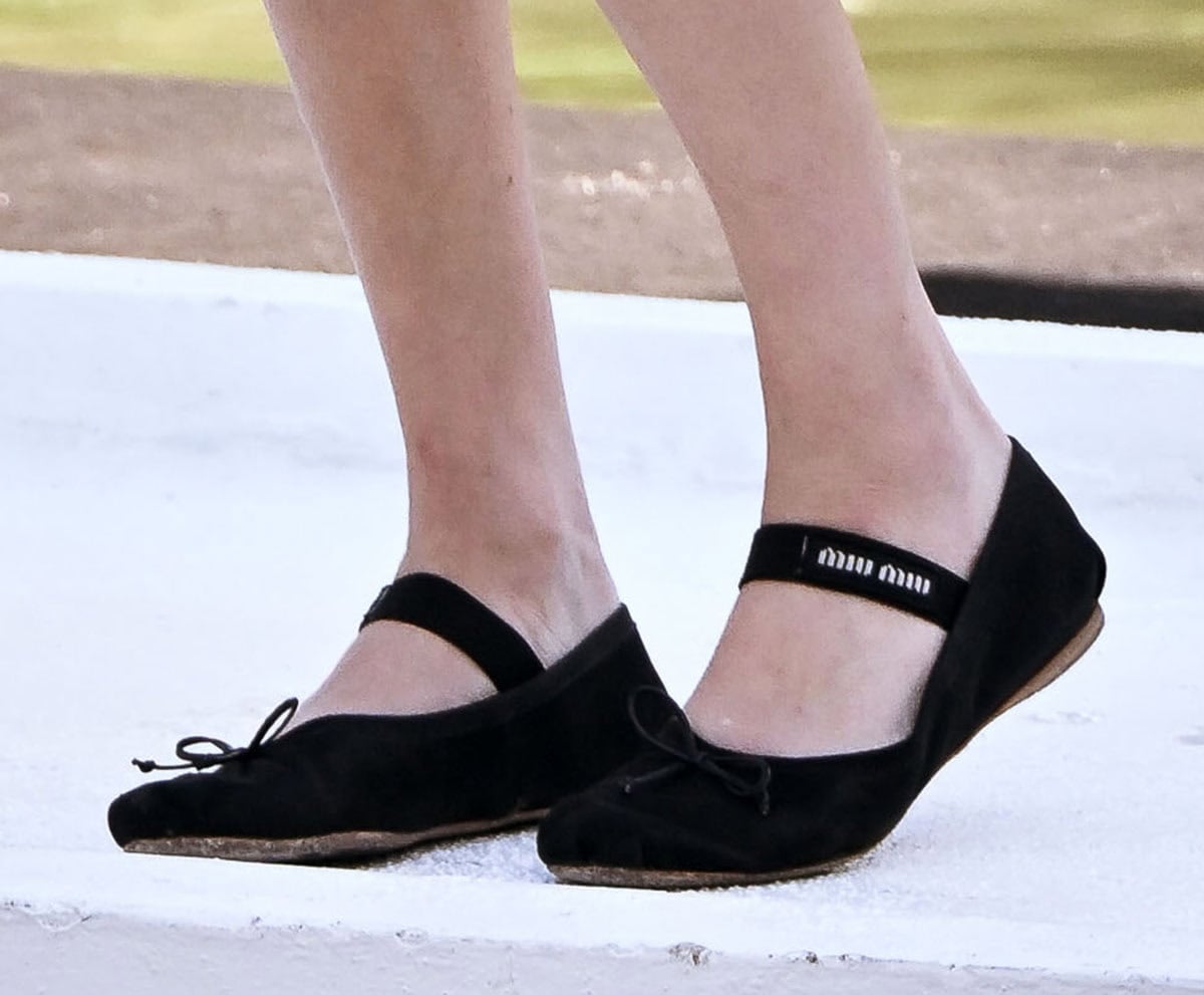 Amanda Seyfried looks laid back in her black satin Miu Miu ballerina flats featuring a dainty front bow and a Miu Miu knit logo on the elasticated instep strap