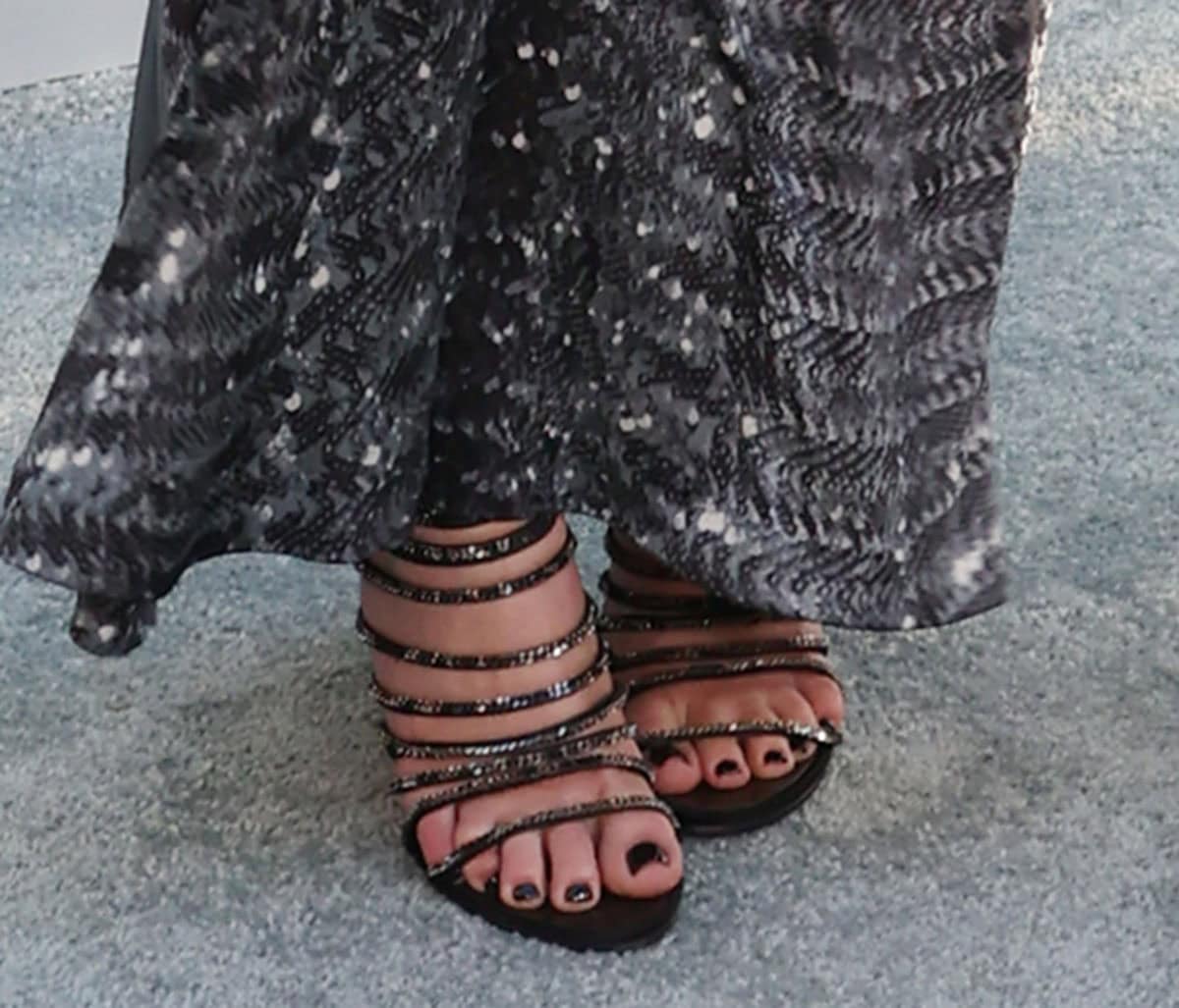 Ashtin Earle steps out in barely-there embellished strappy sandals featuring sparkling multistraps, open toes, and a dark pedicure beneath her archival Maison Margiela dress