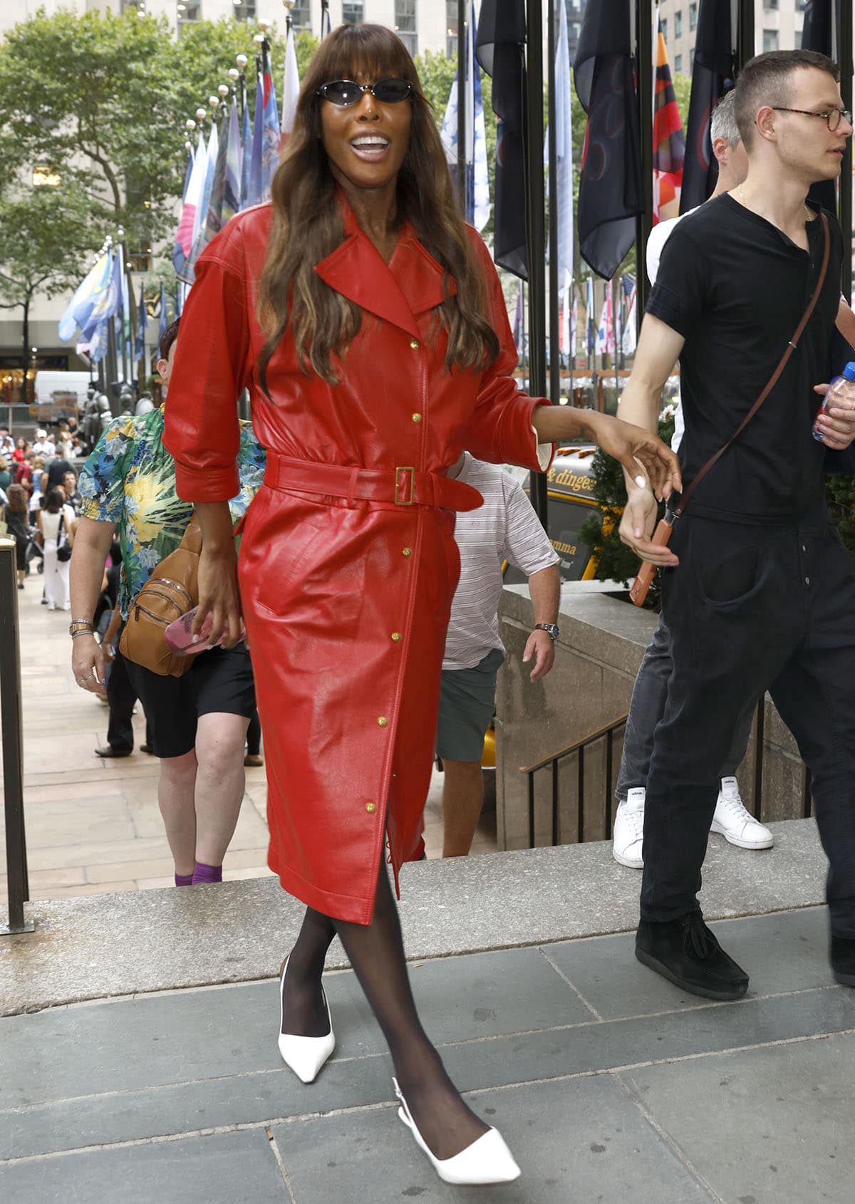 Iman makes the case for bold color contrast, pairing a cherry-red leather trench coat with sheer black stockings and crisp white Sam Edelman Bianka slingback kitten heels
