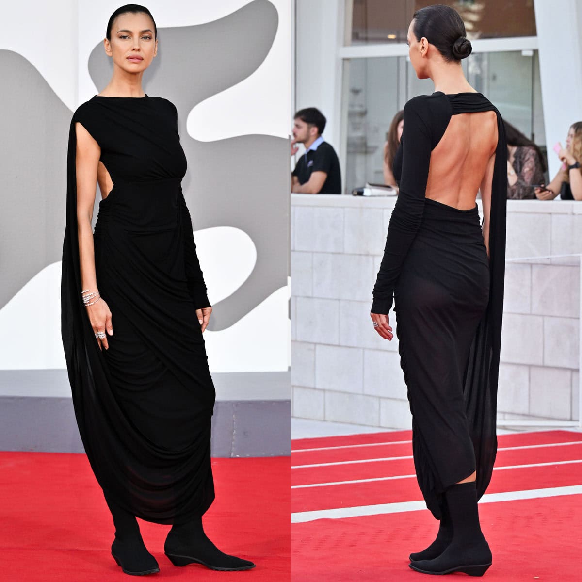 Irina Shayk embraces a dark, avant-garde aesthetic, pairing her black sock boots with a Romeo Gigli draped dress featuring a one long-sleeve design, a cutout back, and a cape-like accent on the right side connected to the hem of the dress