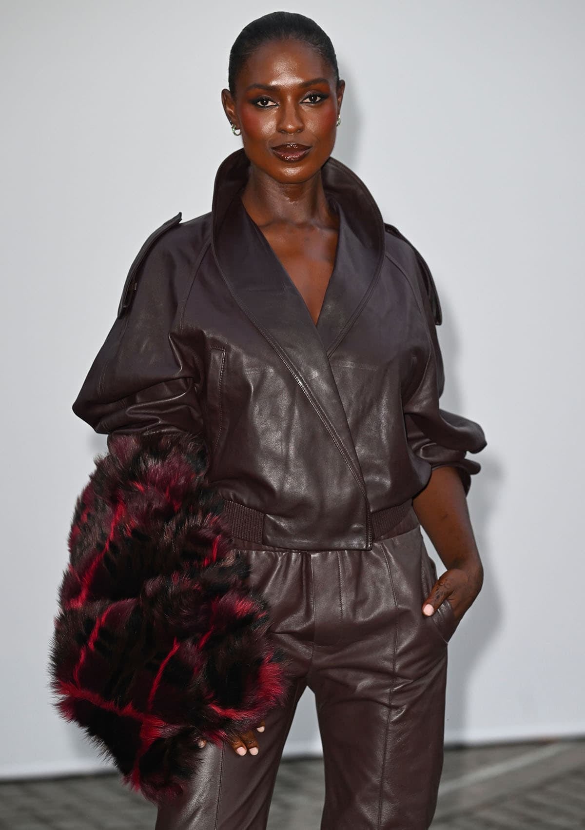 Jodie Turner-Smith wears a burgundy Burberry leather bomber jacket and matching trousers at London Fashion Week
