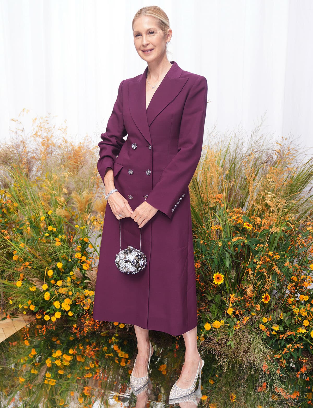 Kelly Rutherford wears a plum Patrick McDowell double-breasted coat dress with jeweled floral buttons at London Fashion Week