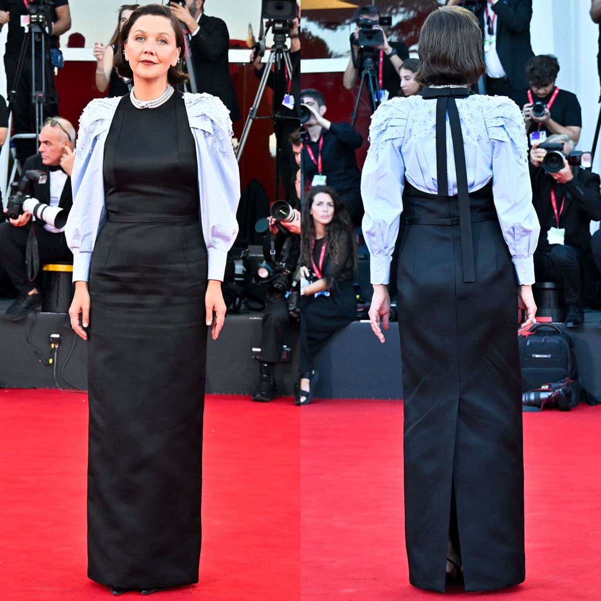 Maggie Gyllenhaal wears a black Prada silk gabardine column gown with crystal-embellished pale blue puff sleeves and black slingback pumps at the 2026 Venice Film Festival closing ceremony