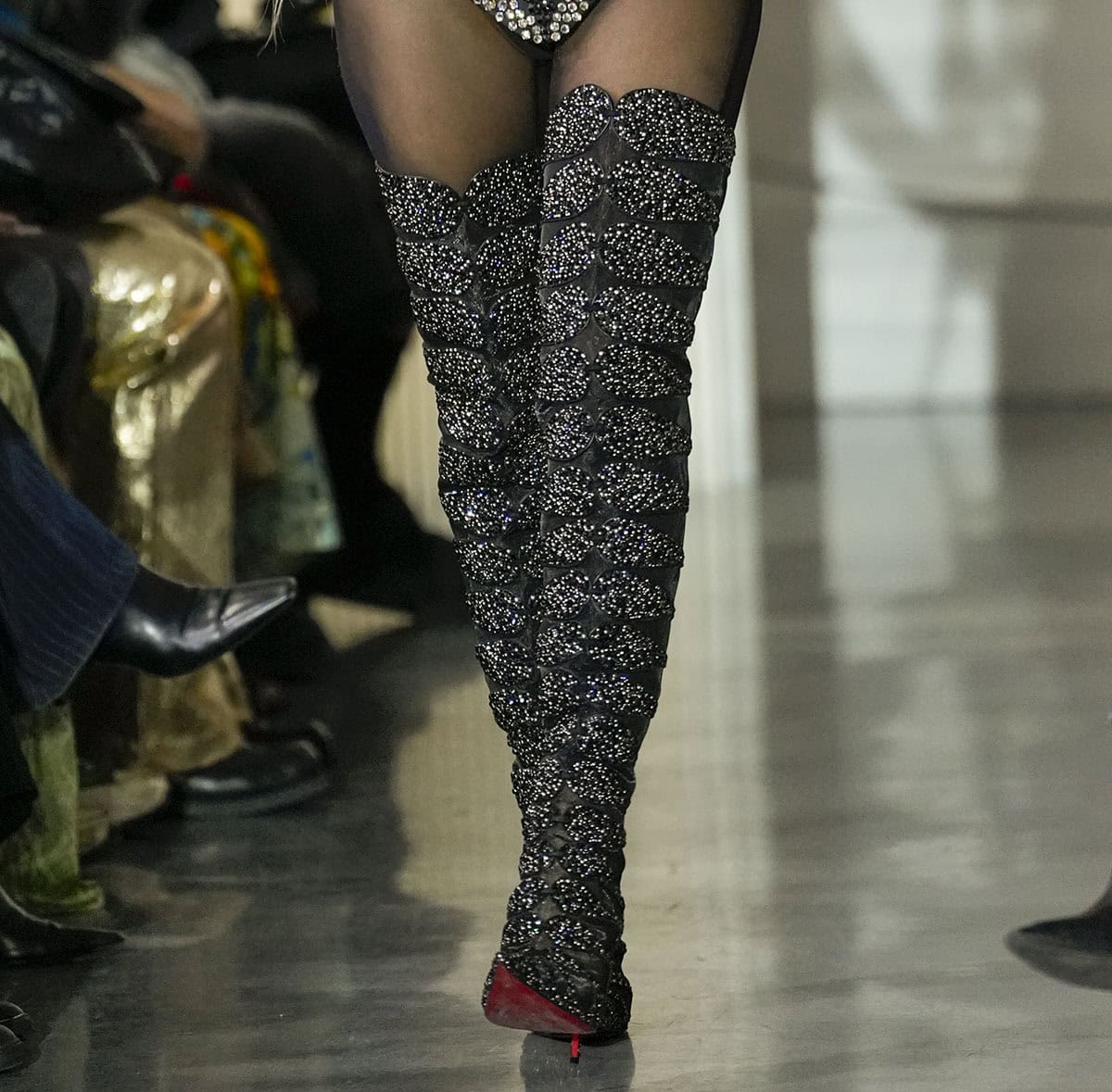 Close-up of Paris Hilton's Christian Louboutin Circus Max Perla Botta Alta boots with crystal-covered suede cutouts and sheer mesh