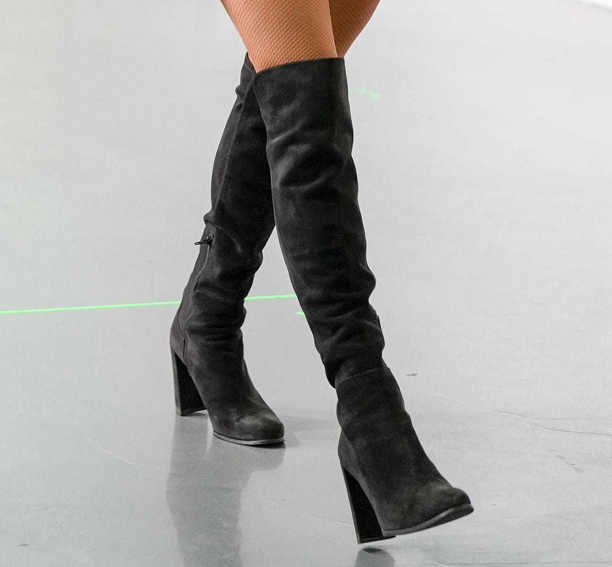 Close-up of Paris Hilton's black suede thigh-high boots with block heels and inner-side zippers