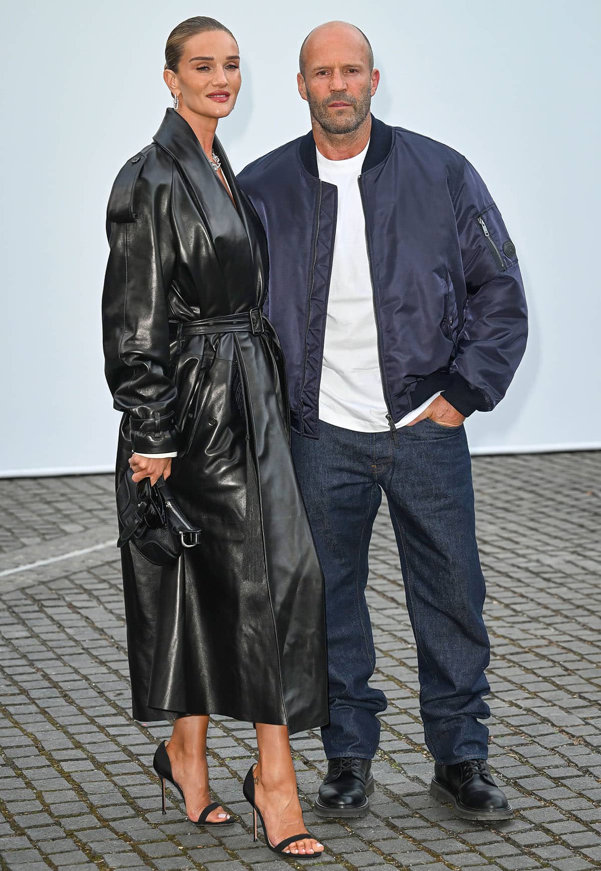 Rosie Huntington-Whiteley in a black Burberry leather trench coat and Aquazzura heels with Jason Statham at London Fashion Week
